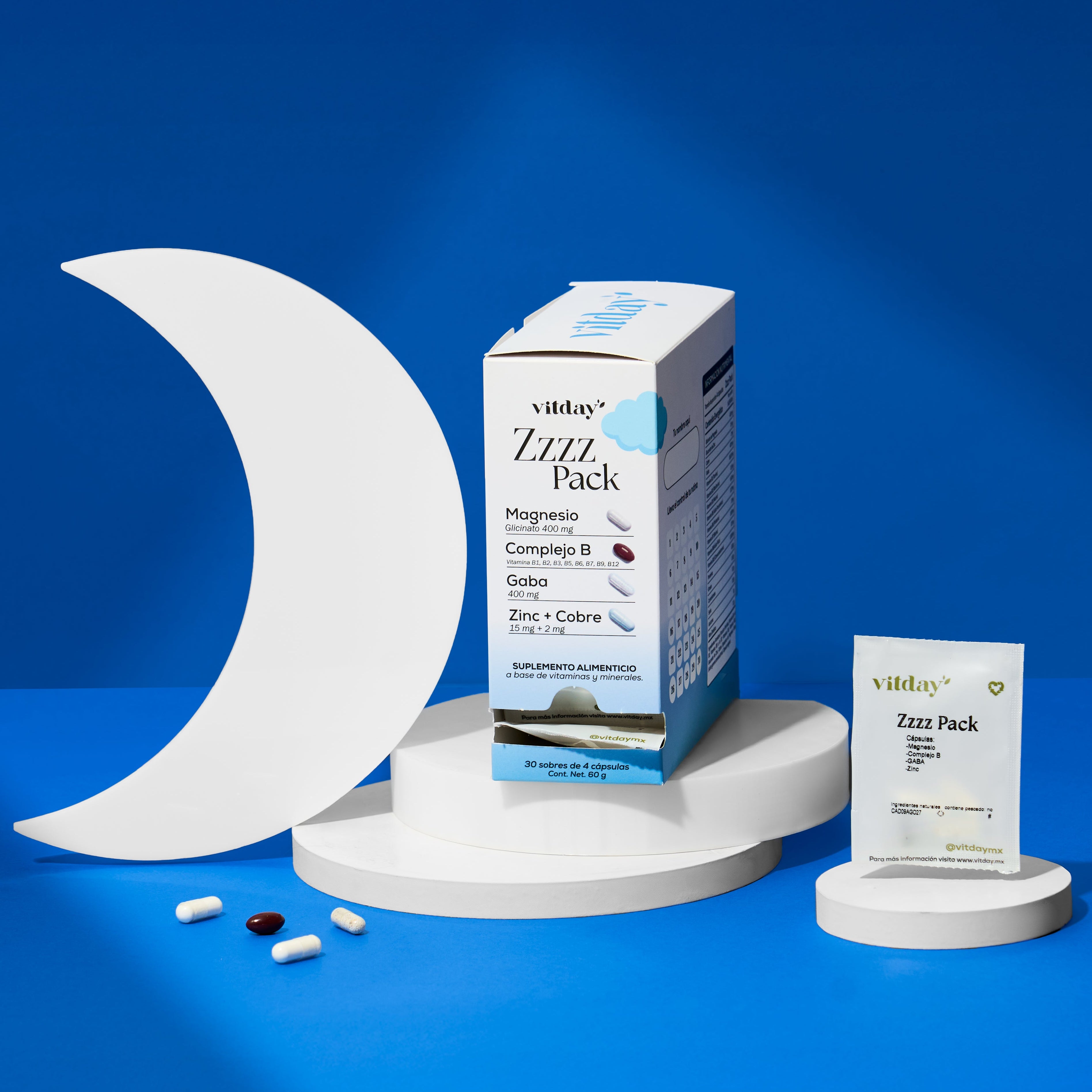 Caja de suplementos Vitamin sobre un pedestal, con cápsulas y un sobre diario.